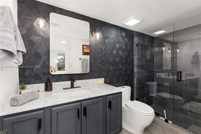 a bathroom with a granite countertop sink toilet and shower