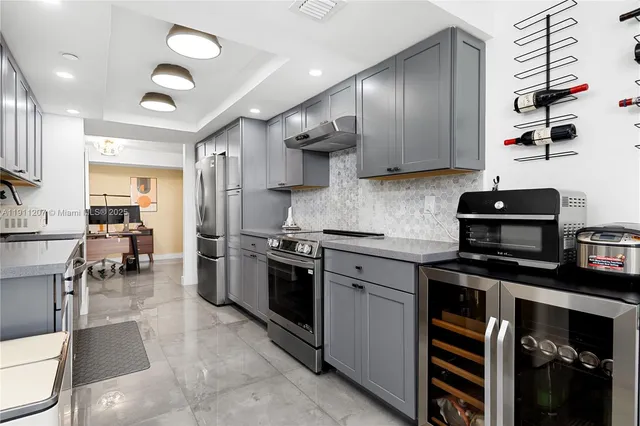 a kitchen with stainless steel appliances granite countertop a stove refrigerator sink and cabinets