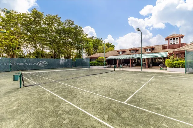a view of a tennis ground with large trees