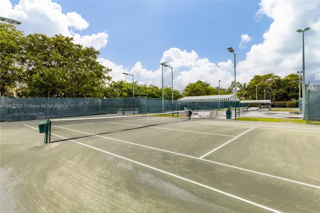 a view of a tennis court with table and chairs