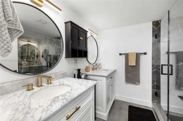 a en suite bathroom with a granite countertop sink and a mirror