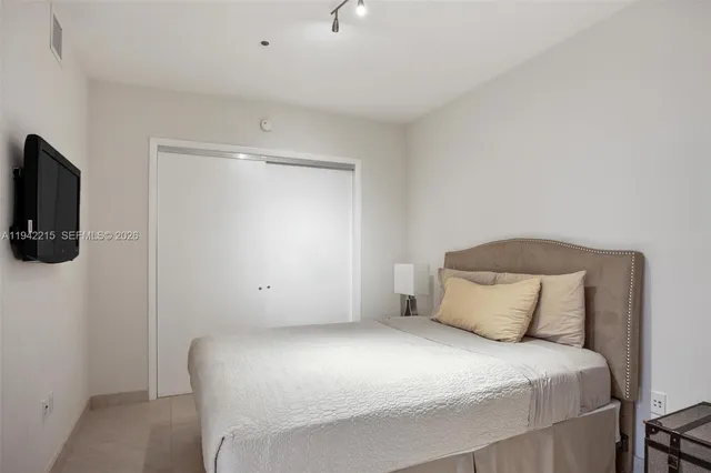 a bedroom with a bed and flat screen tv