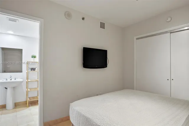 a bedroom with a bed and a flat screen tv
