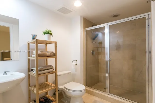 a bathroom with a granite countertop sink toilet and shower