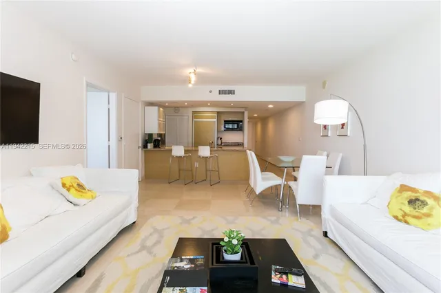 a living room with furniture and kitchen view