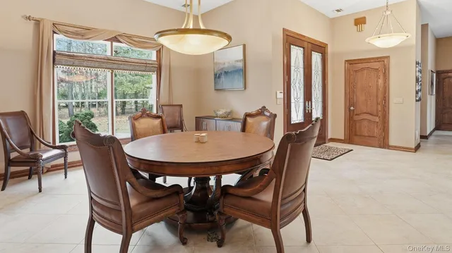 a dining room with furniture a chandelier and wooden floor