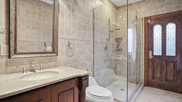 a bathroom with a granite countertop sink a toilet and shower