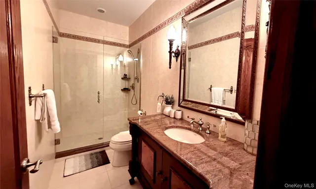 a bathroom with a granite countertop sink toilet and shower