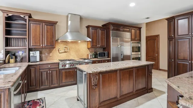 a kitchen with stainless steel appliances granite countertop a stove a sink and a refrigerator