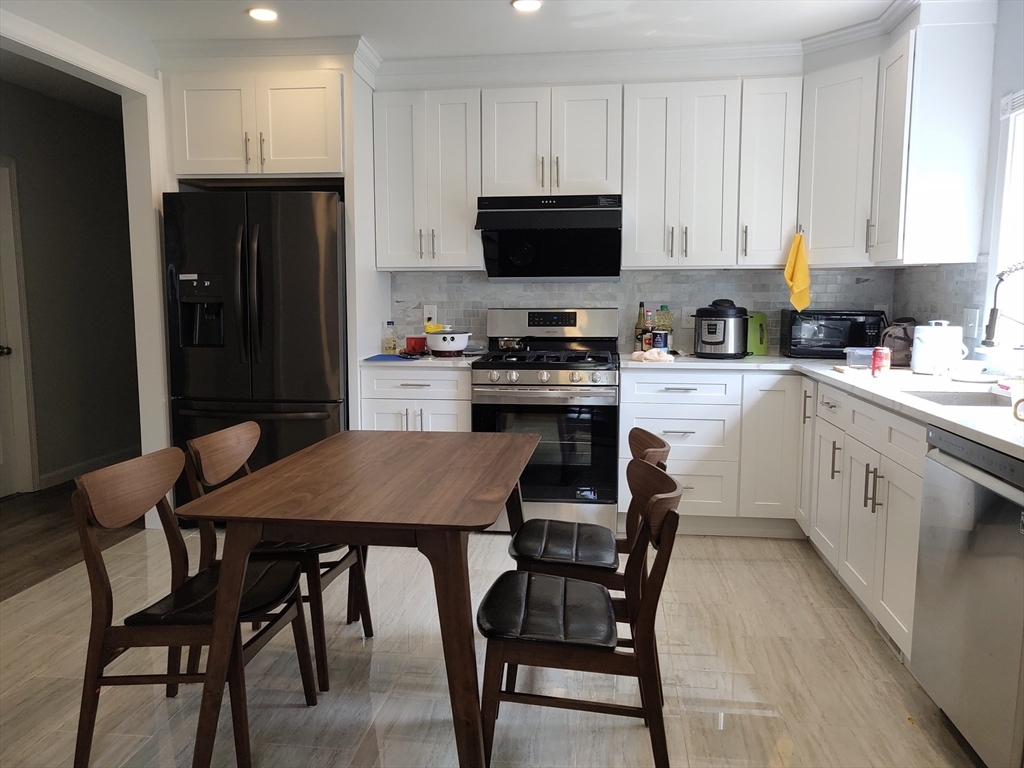 a kitchen with a table chairs refrigerator and cabinets