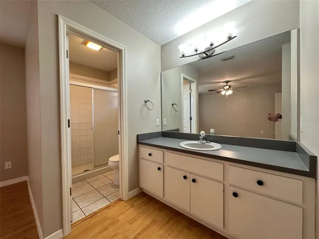 a spacious bathroom with a granite countertop sink mirror and a shower