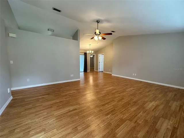 wooden floor in an empty room with a chandelier
