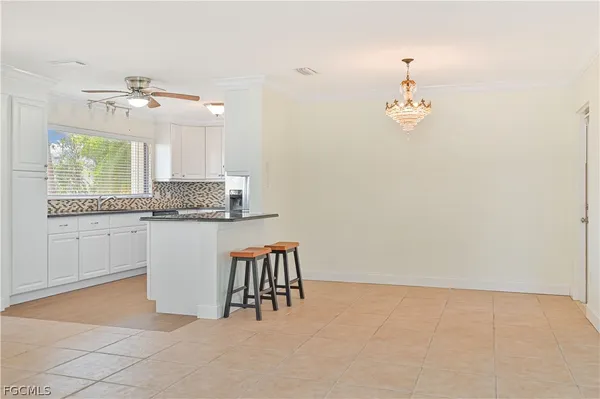 a view of a kitchen with a sink and chandelier fan