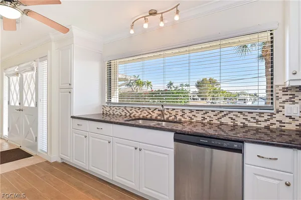 a kitchen with stainless steel appliances kitchen island granite countertop a sink window and cabinets