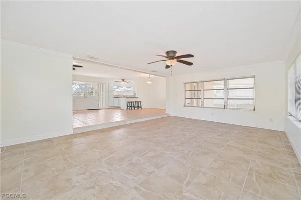 a view of empty room with windows and ceiling fan