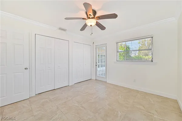 an empty room with windows and fan