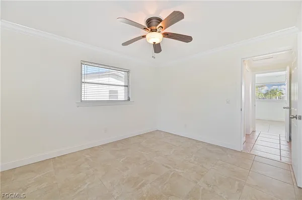 an empty room with fan and windows