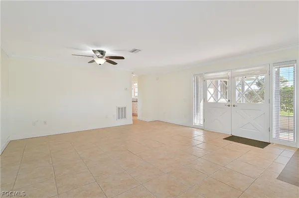 an empty room with windows and fan