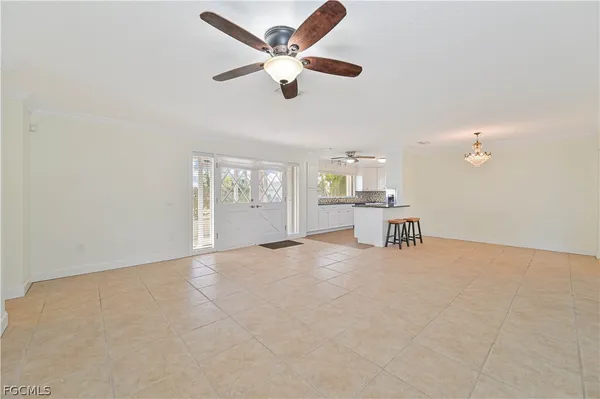 an empty room with windows and ceiling fan