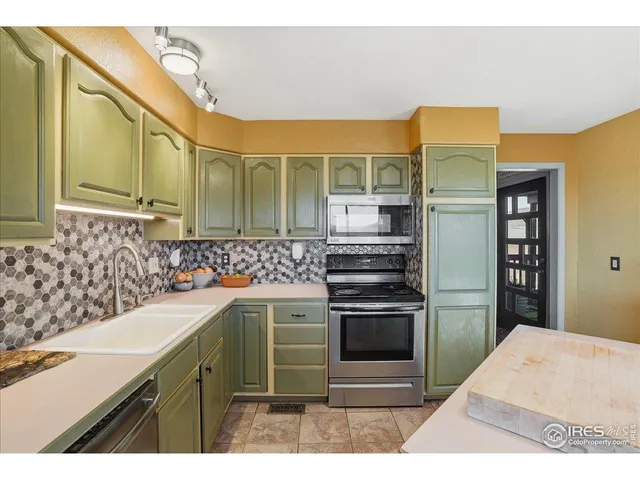 a living room with furniture kitchen view and large windows