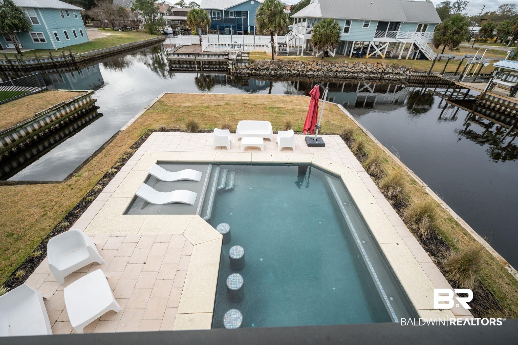 3840 Cotton Way Orange Beach, AL 36561 - Photo 47 of 75 View of swimming pool featuring a lawn, a patio area, and a water view