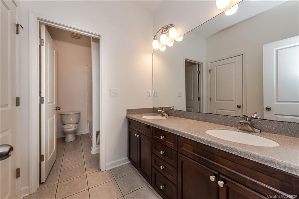 8337 Scotney Bluff Avenue Charlotte, NC 28273 - Photo 23 of 31 a spacious bathroom with a granite countertop sink a toilet and a mirror