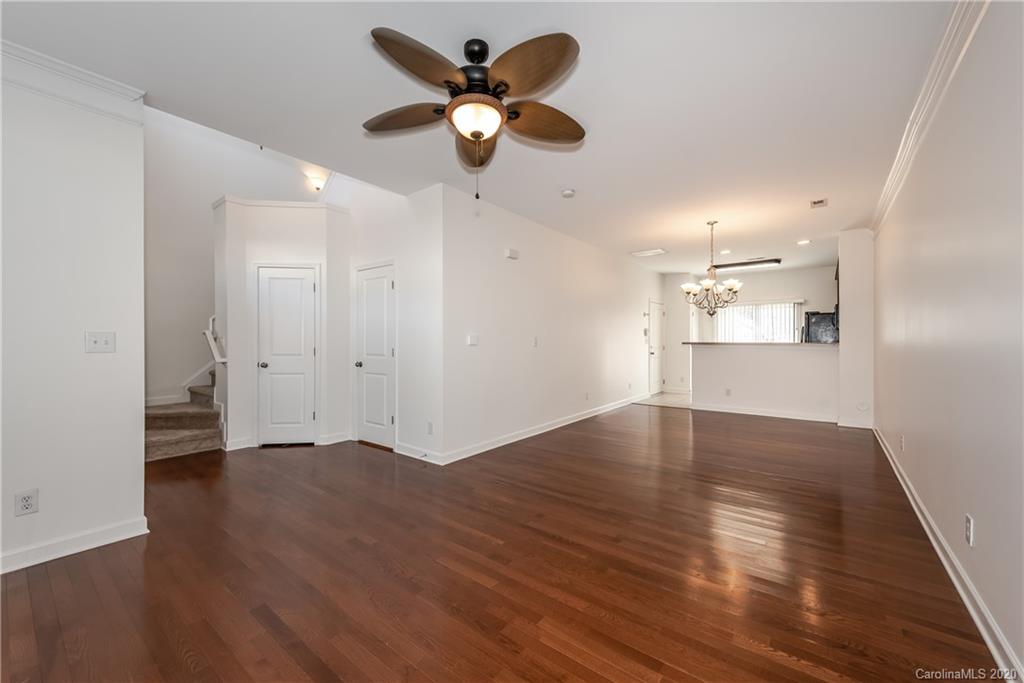 8337 Scotney Bluff Avenue Charlotte, NC 28273 - Photo 7 of 31 a view of an empty room with wooden floor and a ceiling fan
