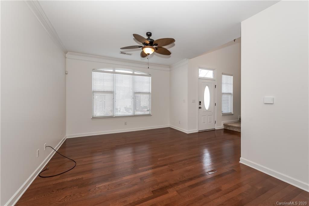 8337 Scotney Bluff Avenue Charlotte, NC 28273 - Photo 8 of 31 an empty room with wooden floor a ceiling fan and windows