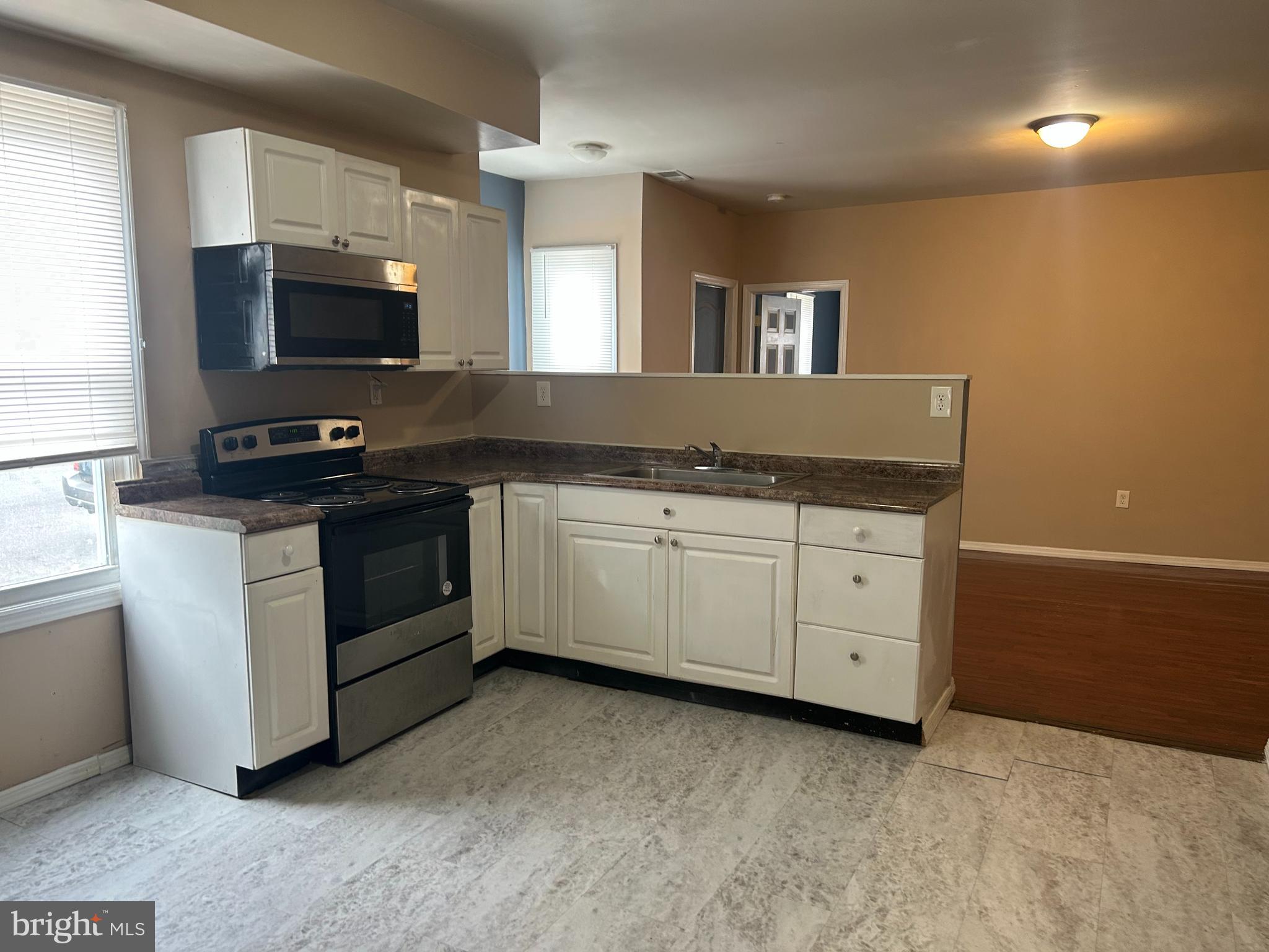 47-49 Hanover Street, Unit 49A Pemberton, NJ 08068 - Photo 7 of 12 a kitchen with granite countertop a stove and a sink