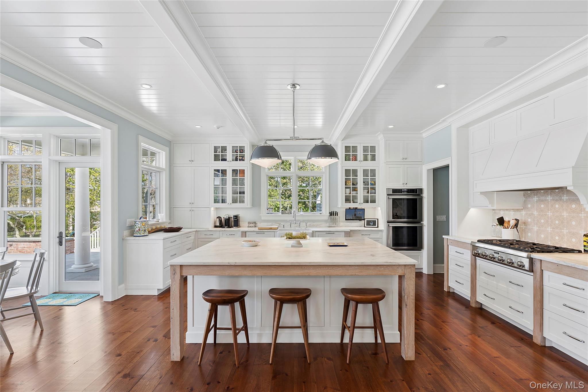43 Old Main Road Quogue, NY 11959 - Photo 5 of 28 a kitchen with stainless steel appliances granite countertop a dining table chairs stove refrigerator and cabinets