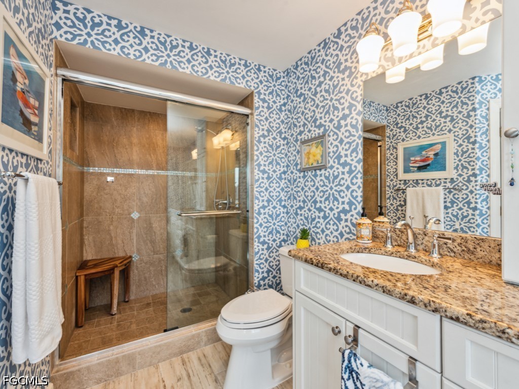 232 La Peninsula Boulevard, Unit 232 Naples, FL 34113 - Photo 18 of 44 a bathroom with a sink a toilet and shower