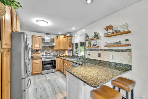 a kitchen with stainless steel appliances granite countertop a sink stove and refrigerator