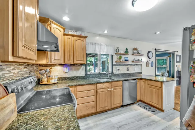 a kitchen with stainless steel appliances granite countertop a sink and cabinets