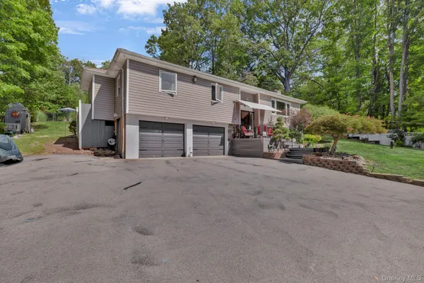 a view of a house with a backyard and parking