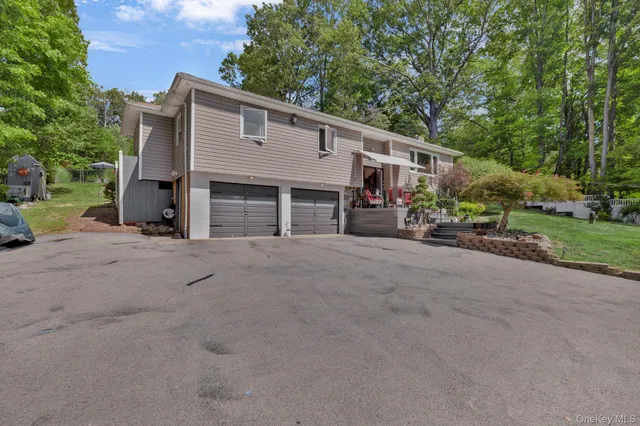 a view of a house with a backyard and parking