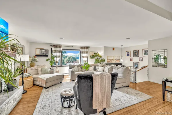 a living room with furniture large window and wooden floor