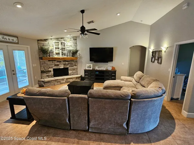 a living room with furniture a flat screen tv and kitchen view