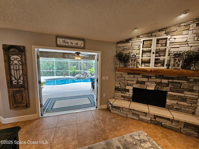 a living room with furniture a chandelier and kitchen view