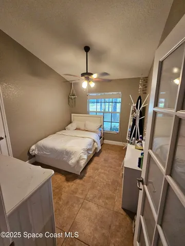a view of a bedroom with wooden floor and furniture