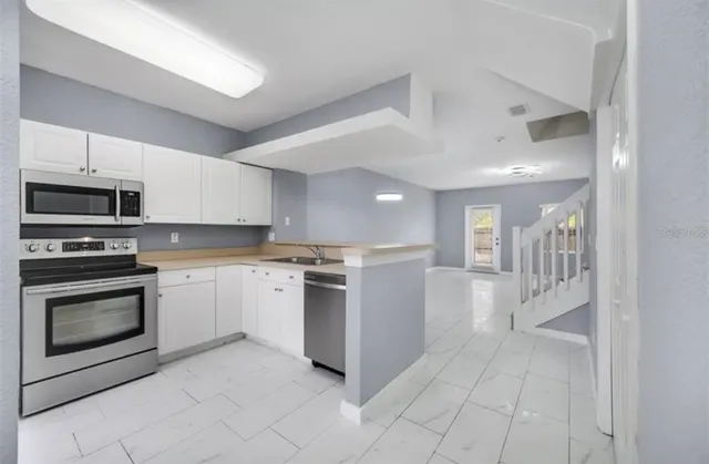 a kitchen with a sink and stainless steel appliances