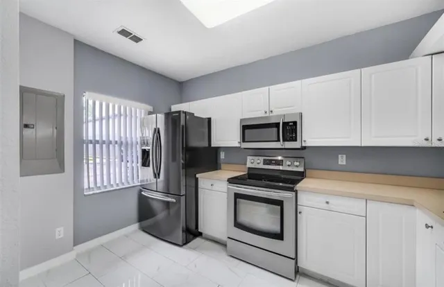 a kitchen with stainless steel appliances a stove microwave and refrigerator