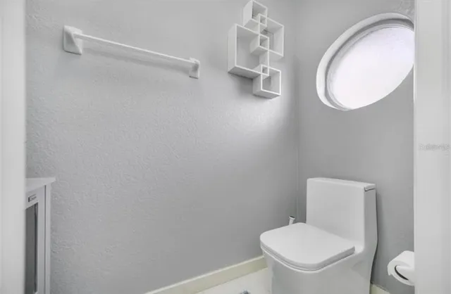a white toilet sitting next to a bathroom sink and vanity