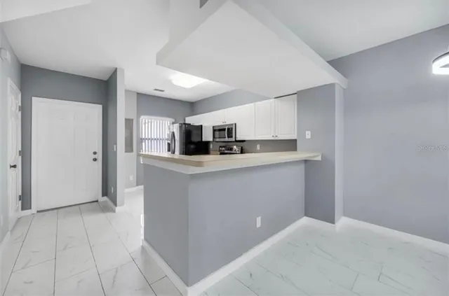 a kitchen with stainless steel appliances granite countertop a sink and a refrigerator