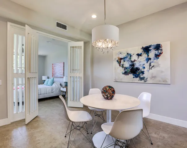 a view of a dining room with furniture a chandelier and wooden floor