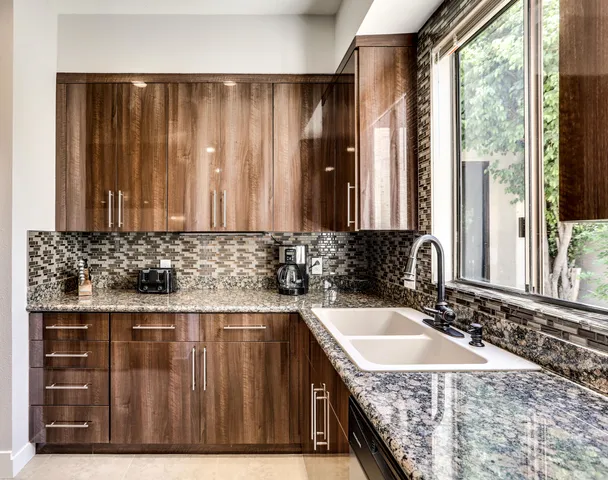 a bathroom with a granite countertop sink and a large mirror