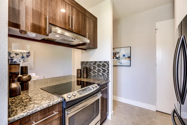 a kitchen with stainless steel appliances granite countertop a stove and a refrigerator