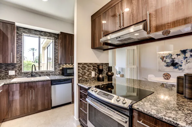 a kitchen with stainless steel appliances granite countertop a sink stove and cabinets