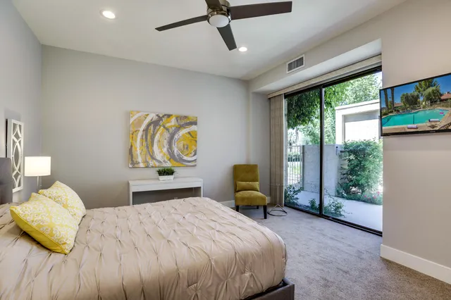 a bedroom with a bed mirror and window
