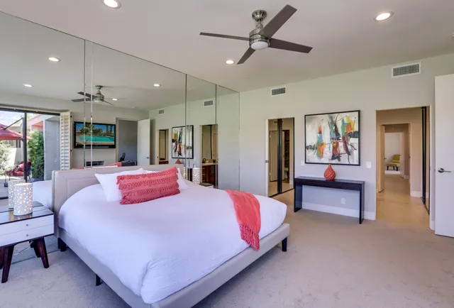 a bedroom with a bed and dresser with mirror