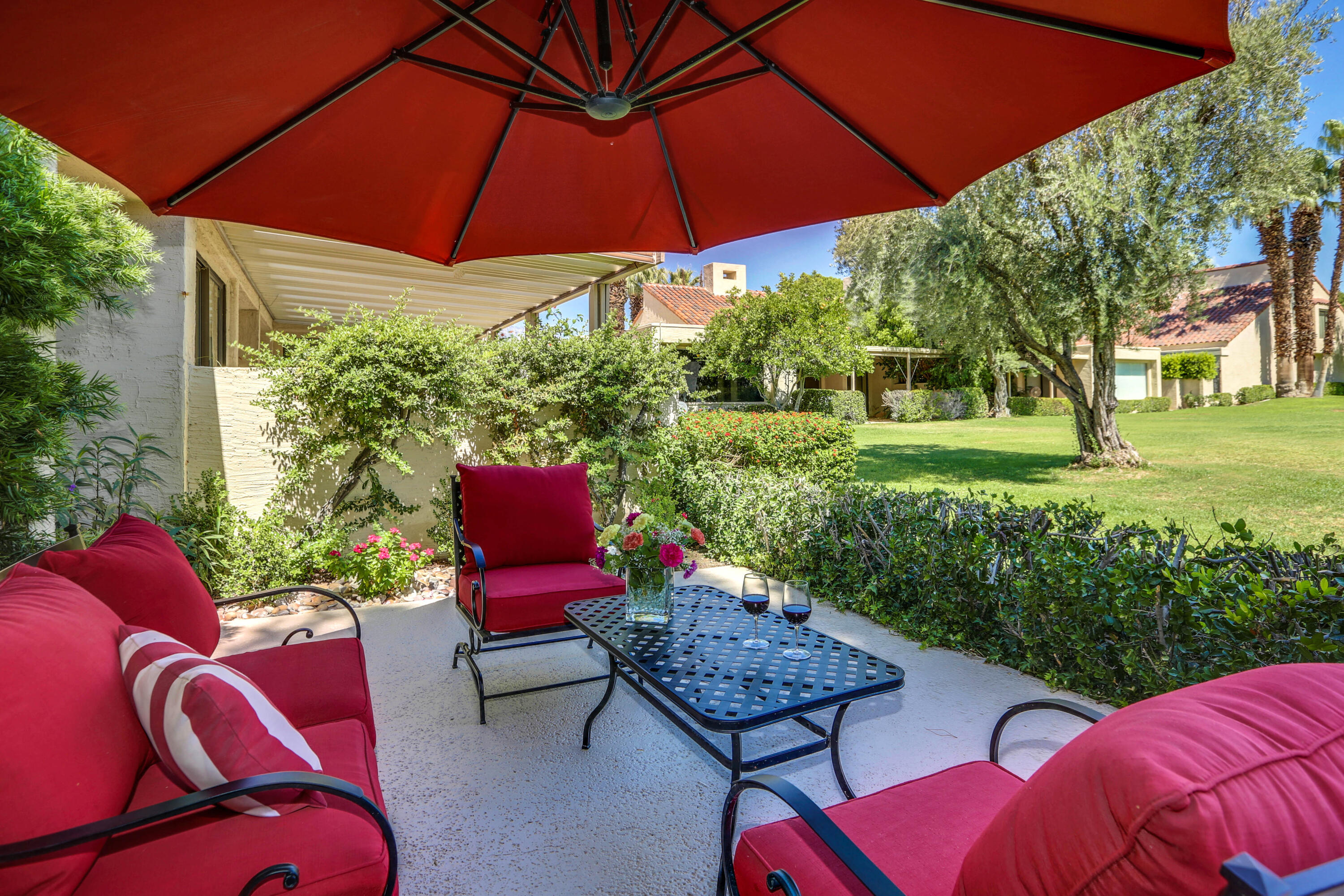 136 Desert W Drive Rancho Mirage, CA 92270 - Photo 34 of 46 a view of a patio with couches chairs and a umbrella